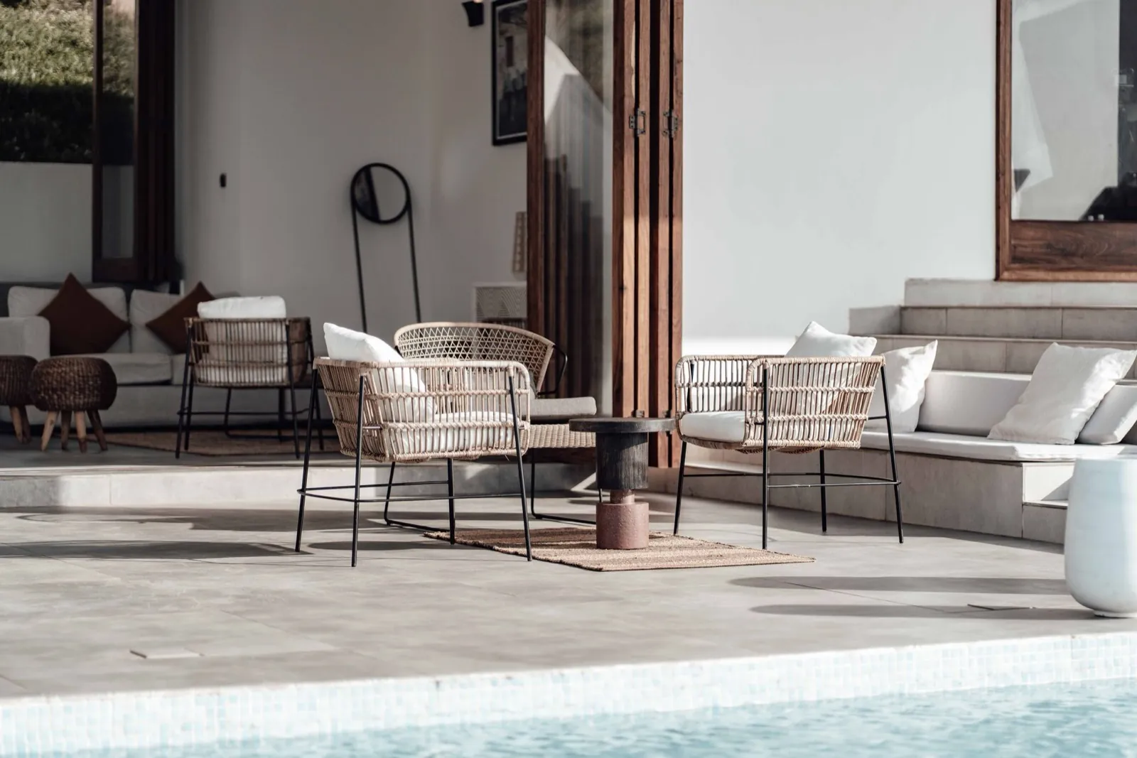 A covered outdoor living area with stone flooring, furnished and finished.